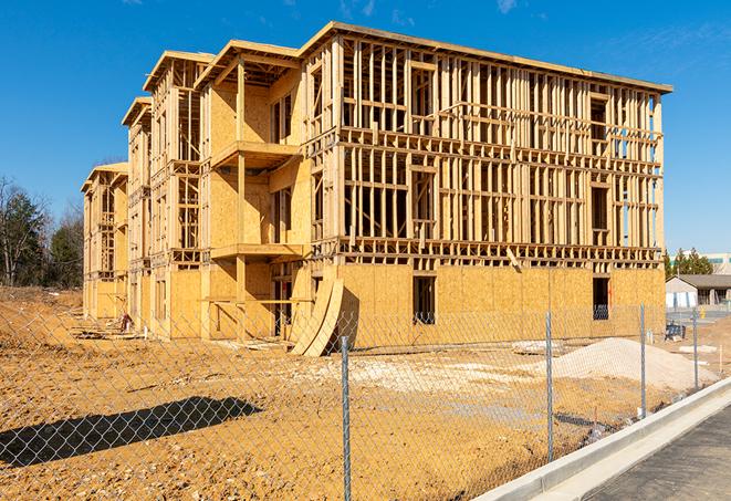 a close-up of temporary chain link fences enclosing a construction site, signaling progress in the project's development in Warrenville, IL